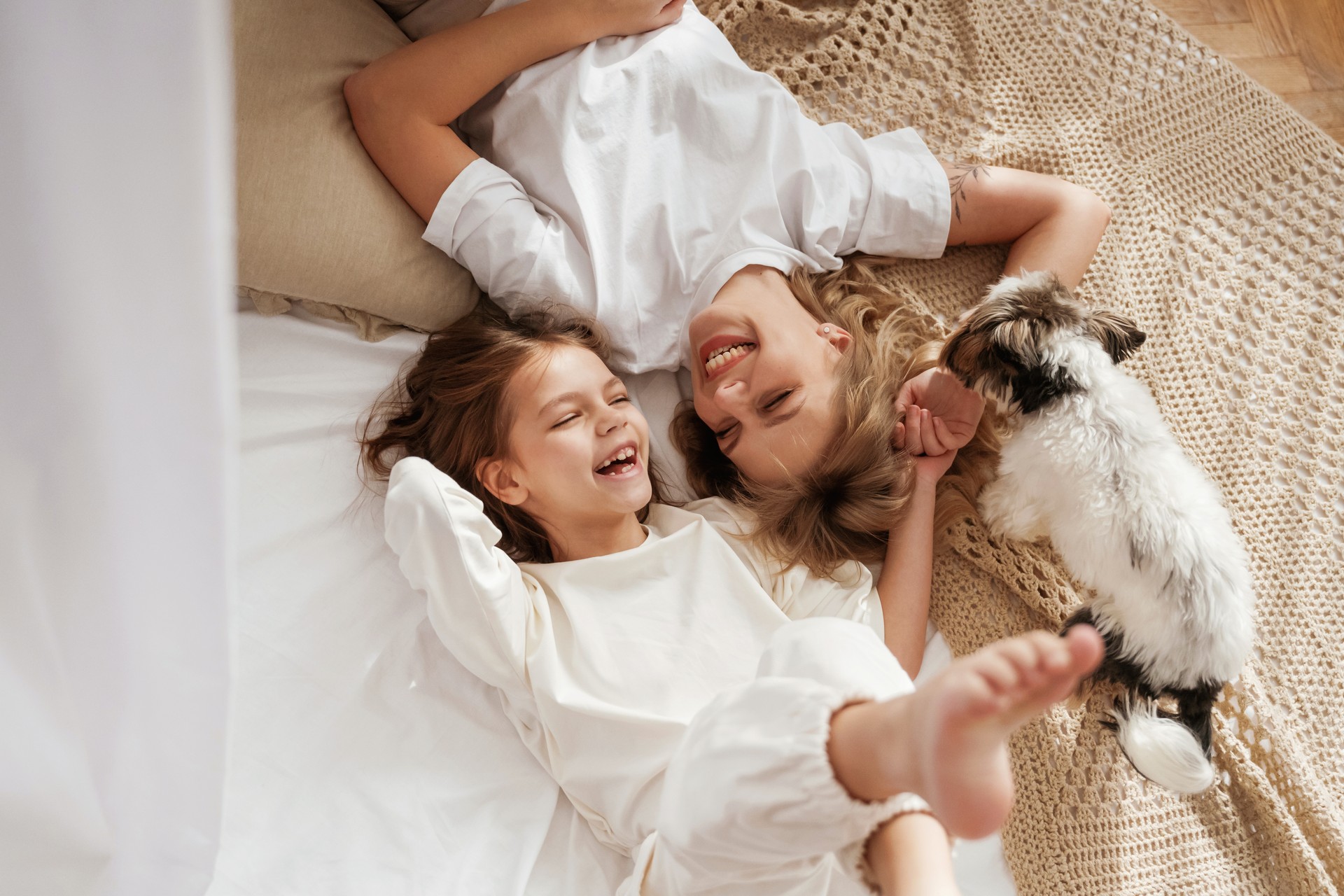 Cute dog is with them. Mother with daughter are at home together